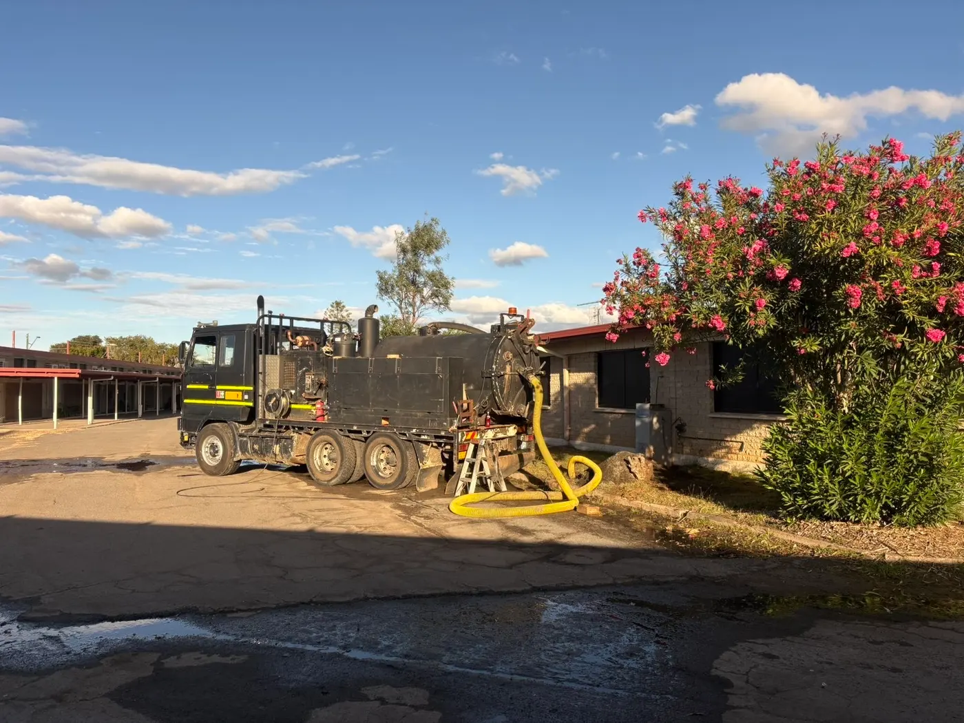 Vacuum truck working with the suction hose in a carpark