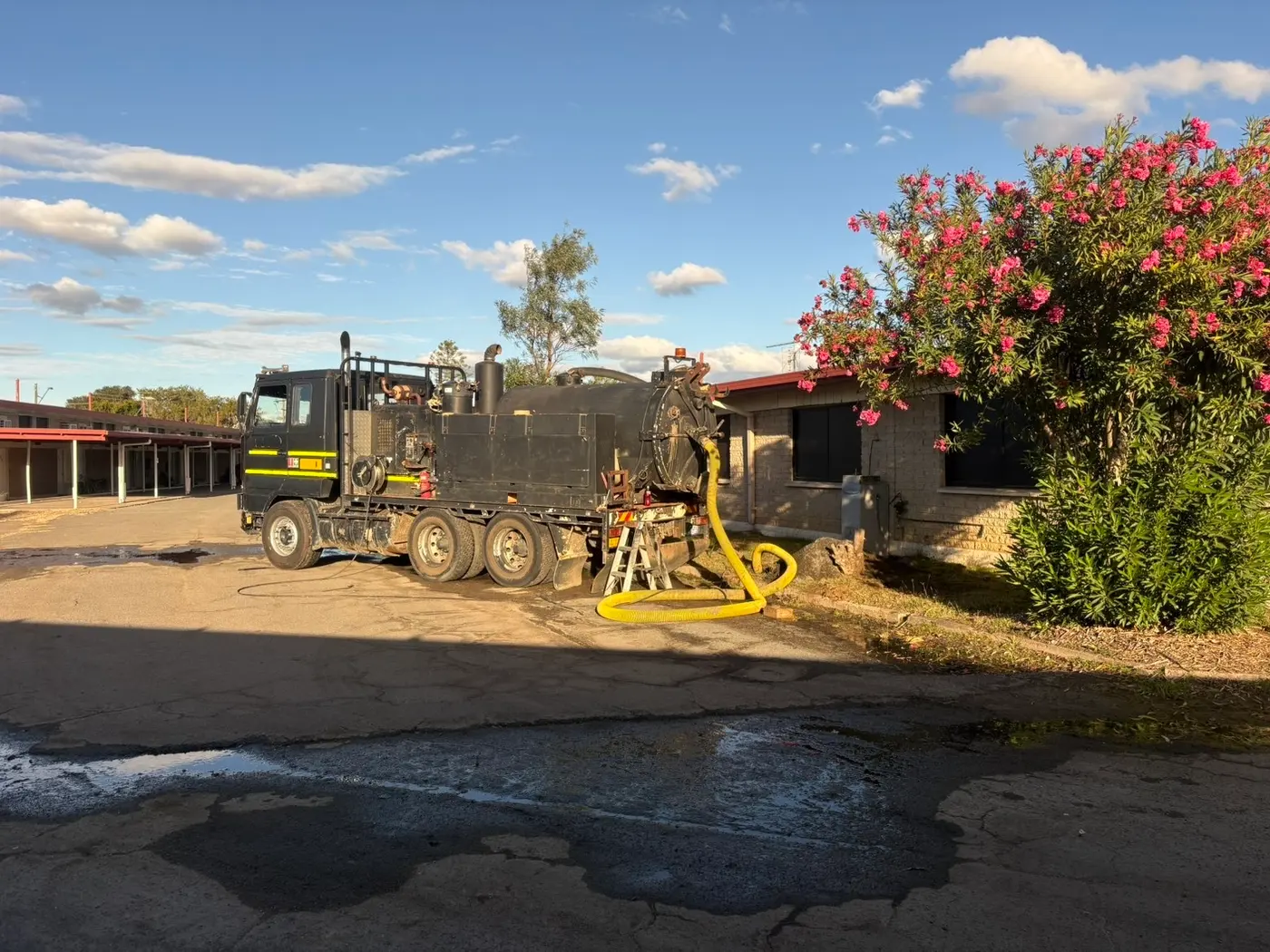 Vac truck with suction hose deployed at a job