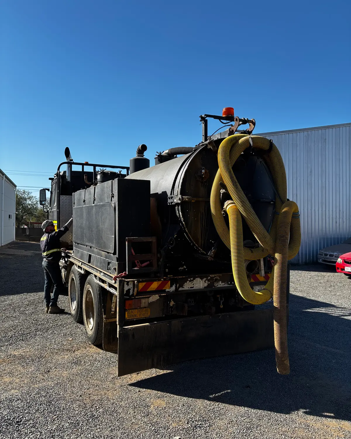 Sid climbing onto the deck of the vacuum truck